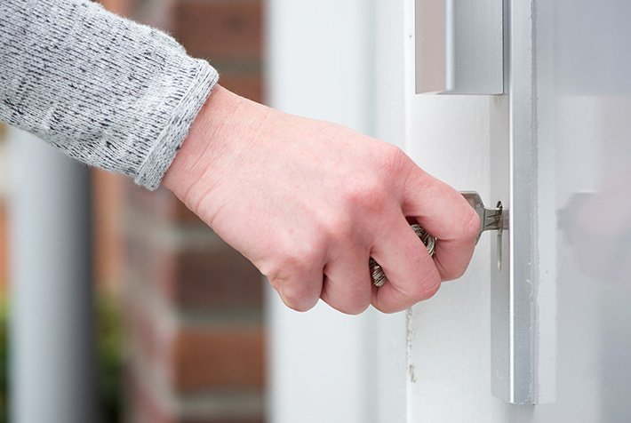 Door locksmith repairing a residential front door lock in Yorktown, NY