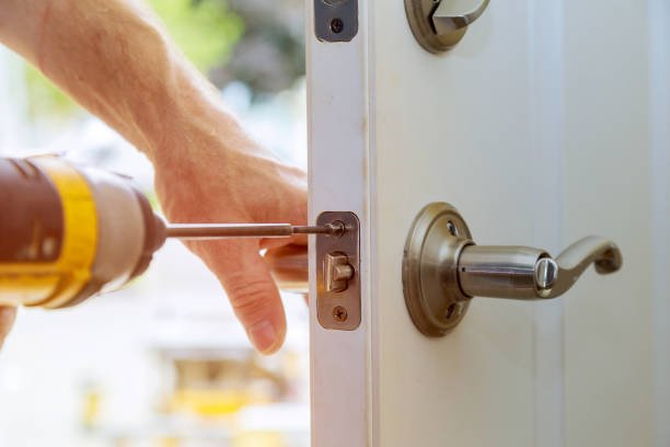 Door locksmith repairing a residential front door lock in Montebello, NY