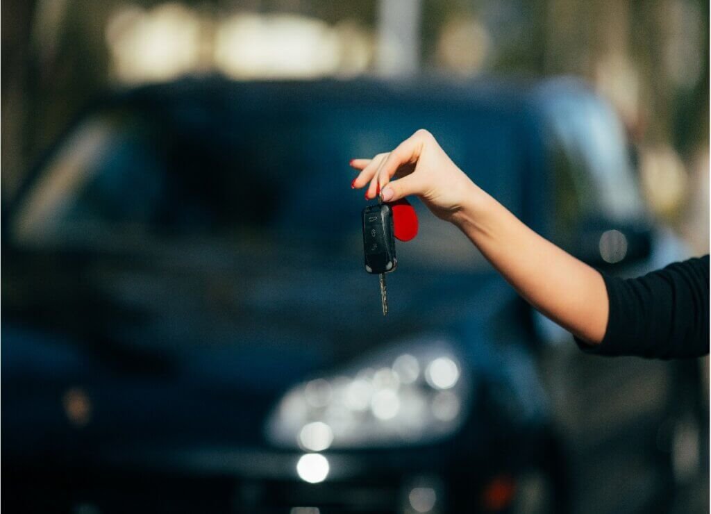 girl hands with jaguar key new car
