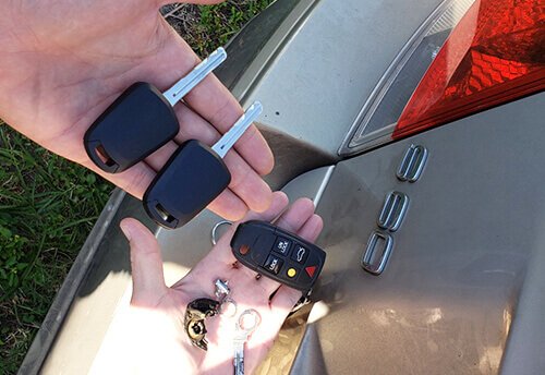 Do You Need Proof of Ownership for Car Key Replacement two hand holding car key