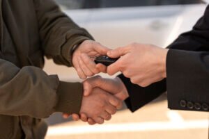 hand of a two person having shake hands and giving key